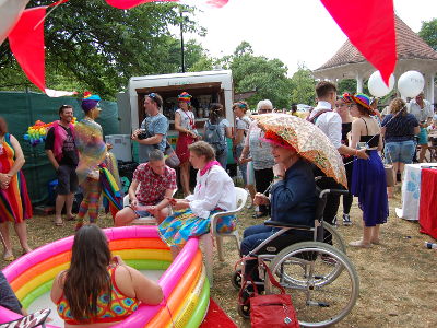 The Norwich Dandies Safe Art Space at Chapelfield Gardens, with many dressed up people and a rainbow paddling pool.