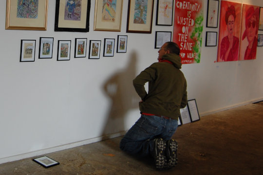 Vince Laws hanging new work in the exhibition at St Margaret's Church of Art. The work is of re-appropriated Alice in Wonderland images with funny and surreal texts superimposed over them to subvert the story and incorporate Vince's poems and ideas.