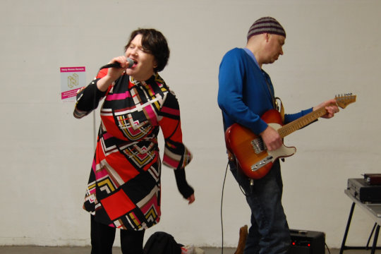 On the opening night event at the Nasty Women Norwich exhibition we had a great line up of talented musicians to perform to the crowd. In this image the Norwich duo Ruby Flipper is performing. Emma Jarvis is singing and is accompanied by guitarist Stephen Little.