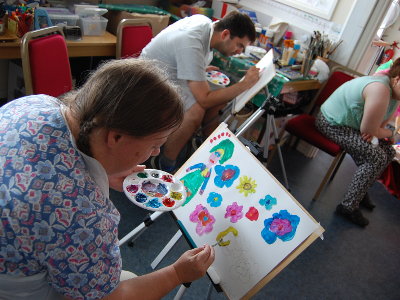 A female artist concentrating on her painting.